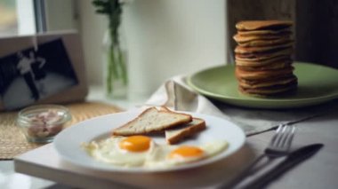 Kahvaltı tabağı. Mutfak masasında ekmek tost ve gözleme yığını ile kızarmış yumurta
