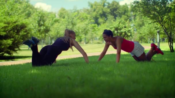 Mulher, faz exercício. Mulher fitness empurrando na grama verde no parque — Vídeo de Stock