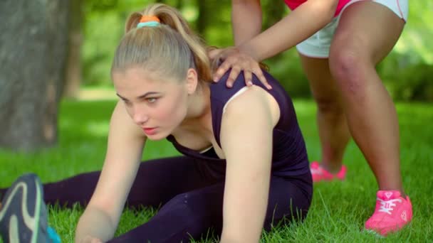 Ejercicios de estiramiento al aire libre. Primer plano de mujer caucásica estirándose en parque — Vídeos de Stock