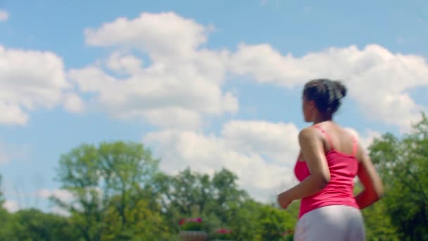 Mulattin joggt in Zeitlupe vor blauem Himmel mit Wolken — Stockvideo