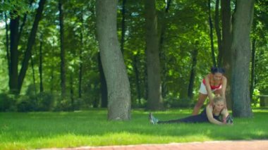 Park yeşil çimenlerin üzerinde germe egzersiz yaparak fitness kadın