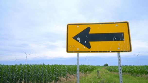 Panneau routier pointant vers la ferme des turbines à ailes. Champ agricole avec éoliennes — Video