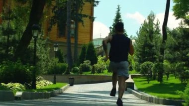 Park yolunda koşan bir adam. Park sokağında yavaş çekimde kaçmak
