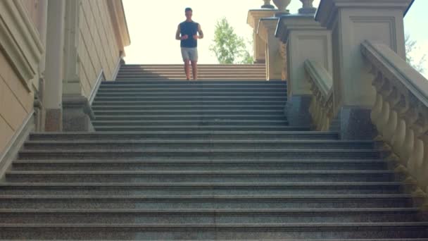 スローモーションで階段をジョギングする男。階段を駆け下りる男 — ストック動画
