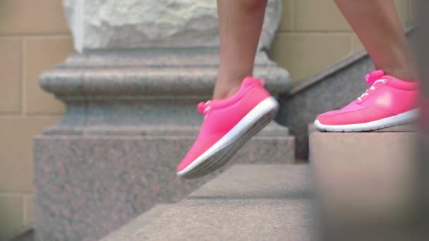 Benen in sportschoenen lopen naar beneden trappen in slow motion — Stockvideo