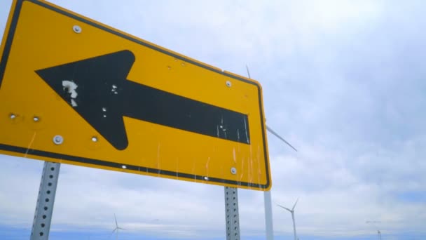 Wind turbine generator on green farm field. Road sign pointing on wind turbines — Stockvideo