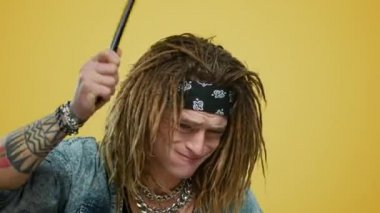 Stüdyoda davul çalan duygusal müzisyen. Elinde bagetler tutan adam.