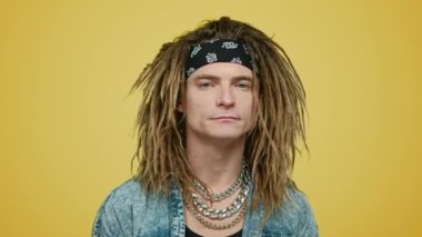 Stüdyoda yükselen adam. Sarı arka planda duran ciddi bir adam.