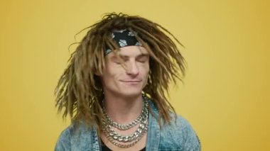 Sarı arka planda kafasını sallayan bir adam. Hippi stüdyoya giriyor.