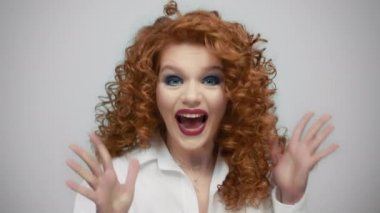 Gri arka planda evet işareti yapan bir kadın. Başarıyı kutlayan kız