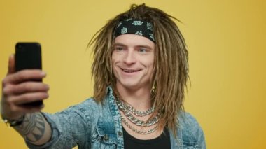 Gülümseyen adam akıllı telefondan selfie çekiyor. Cep telefonu kullanan hippi