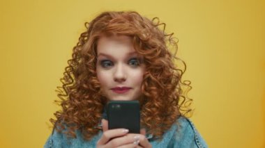 Akıllı telefondan iyi haberler okuyan şaşırmış bir kadın. Mutlu kız başarıyı kutluyor