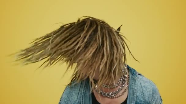 Rocker κουνώντας το κεφάλι σε κίτρινο φόντο. Hipster κινείται σώμα με μουσική — Αρχείο Βίντεο