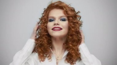 Kamerayla flört eden seksi kadın. Stüdyoda gülümseyen kızıl saçlı kız.
