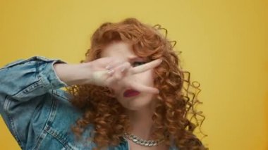 Sarı arka planda dans eden kadın. Kız dans ederken komik hareketler yapıyor.