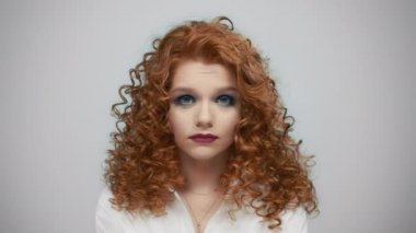 Gri arka planda esneyen bir kadın. Stüdyoda kameraya esneyen sıkıcı kız.