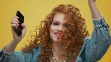 Elinde akıllı telefonla dans eden bir kadın. Kız cep telefonuyla müziğe geçiyor