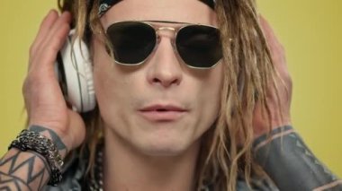 Stüdyoda kulaklık takan bir adam. Kulaklıkla müzik dinleyen adam.