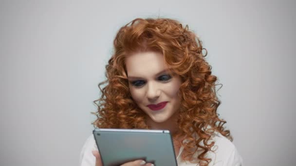 Mujer usando tableta digital en el estudio. Chica leyendo buenas noticias en la pantalla de la tableta — Vídeo de stock