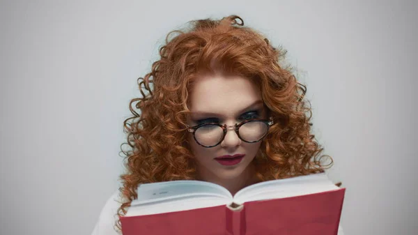 Serious student holding book in studio. Portrait of girl turning pages of book — Stock Photo, Image