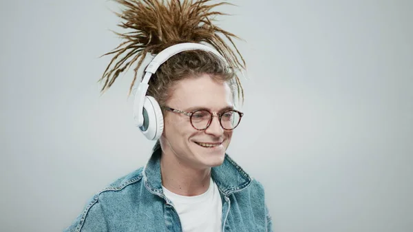 Hombre sonriente bailando con auriculares en el estudio. Tipo escuchando música en auriculares —  Fotos de Stock