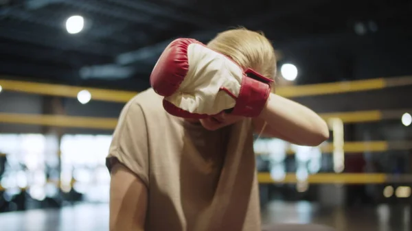 Vyčerpaná boxerka utírá pot ve sportovním klubu. Fitness žena sedí v posilovně — Stock fotografie