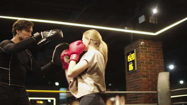 Deporte serio par de boxeo en el gimnasio. Entrenamiento de chica en forma con entrenador en club deportivo — Foto de Stock