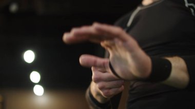Spor salonunda el ele tutuşan tanınmamış bir adam. Erkek eller savaşa hazırlanıyor.