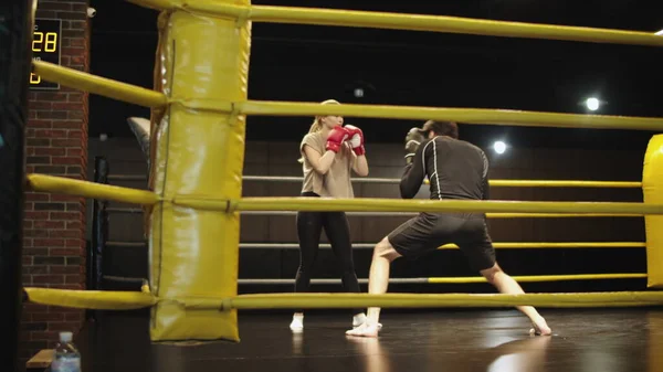 Joven entrenador enseñando boxeador femenino en el club deportivo. Entrenamiento de mujer deportiva en gimnasio — Foto de Stock