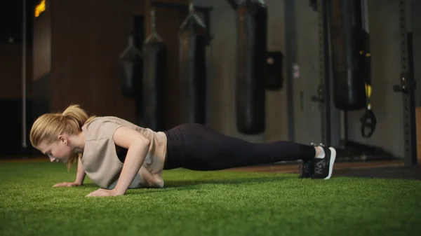 Boxeadora activa haciendo flexiones en el club deportivo. Chica en forma calentando en el gimnasio — Foto de Stock