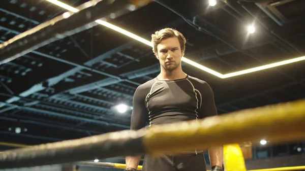 Boks ringinde yumruk atan kızgın zinde bir adam. Sporcu adam dövüşmeye hazırlanıyor. — Stok fotoğraf