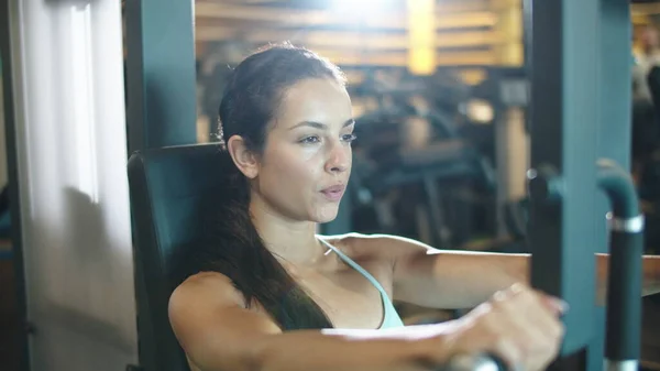 Atractiva mujer deportiva haciendo rizos de bíceps en el gimnasio. Chica en forma haciendo ejercicio en el club — Foto de Stock