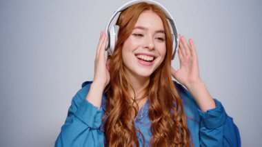 Stüdyoda dans eden neşeli kız. Gri arka planda hareket eden kadın