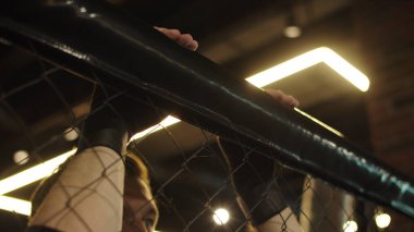 Spor kulübünde tanınmayan bir adam yaslanıyor. Erkek kişi spor salonunda dinleniyor.