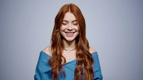 Una mujer encantadora mirando la cámara en el estudio. Chica sonriendo sobre fondo gris —  Fotos de Stock