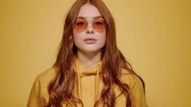 İçerideki kameraya bakan güzel kız. Turuncu arka planda objektifte rol alan kadın