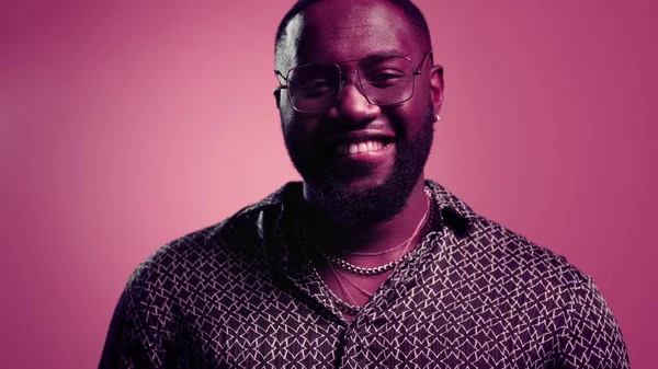 Guapo afro chico coqueteando sobre fondo rosa. Africano haciendo beso en estudio — Foto de Stock