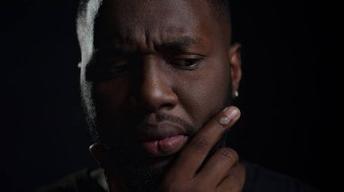 Kapalı alanda karar vermeye odaklanmış bir afro adam. Afrikalı adamın yüzü.