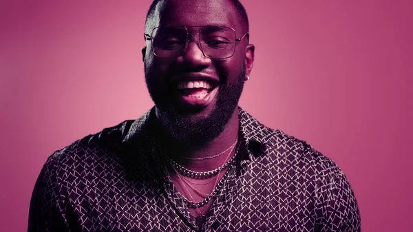 Boldog afro srác nevet odabent. Férfi személy vihog rózsaszín háttér — Stock Fotó