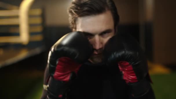 Atleta masculino ansioso haciendo golpes en el club deportivo. Boxeador entrenamiento patadas en el gimnasio — Vídeo de stock