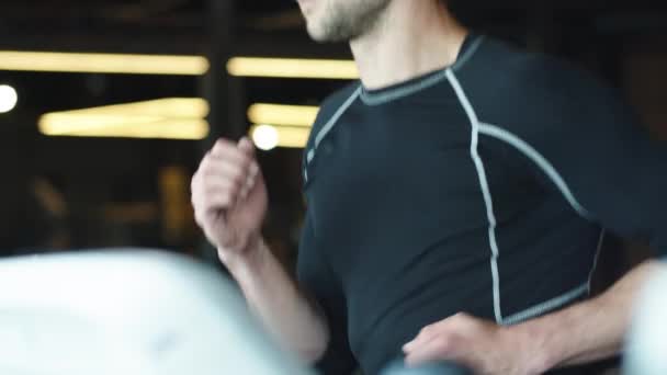 Aktywny sportowiec ćwiczący cardio na siłowni. Fit man biegający na bieżni w klubie sportowym — Wideo stockowe