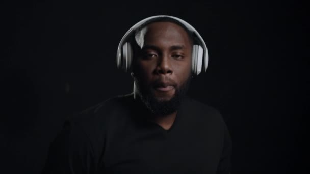 Smiling afro guy dancing indoors. Portrait of funny african man in headphones — Stock Video