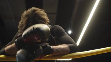 Boksör spor salonunda dövüşten sonra mola veriyor. Formda adam spor kulübünde dinleniyor.