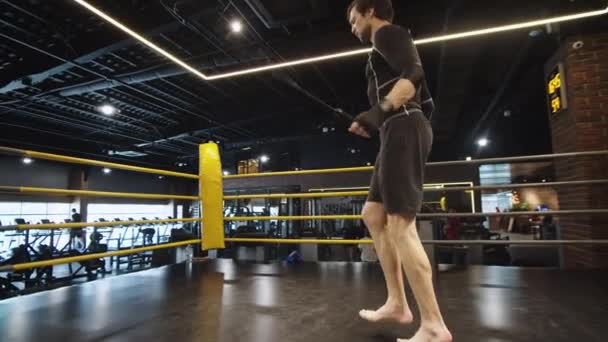 Hombre deportivo enérgico haciendo saltos en el gimnasio. Boxeador masculino ejercitándose en club deportivo — Vídeo de stock