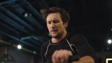 Spor salonunda egzersiz yapan yorgun ve formda bir adam. Spor adamı spor salonunda ısınıyor.