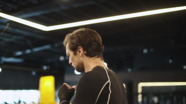 Enfocado hombre en forma calentando en el club deportivo. Boxeador masculino usando cuerda de salto en el gimnasio — Vídeo de stock