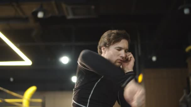 Homme sportif strict échauffant les coudes dans le centre de remise en forme. Boxer faisant de l'exercice au gymnase — Video