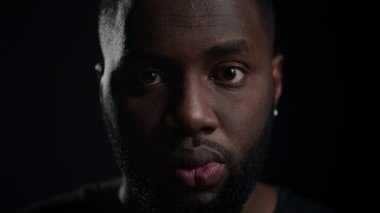 Stüdyoda poz veren neşeli adam. Siyah arka planda konuşan mutlu afro adam.