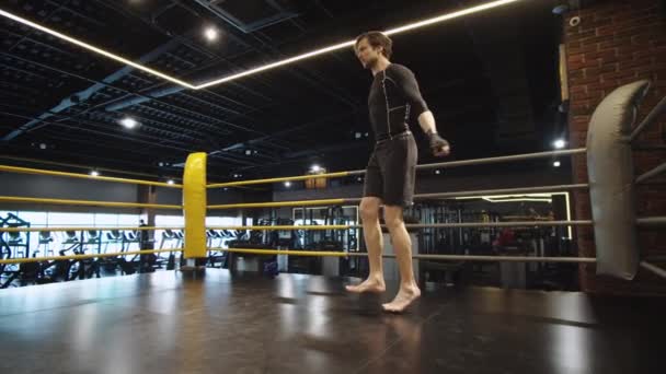 Hombre deportivo haciendo saltos en el club deportivo. Boxeador masculino haciendo ejercicio en el gimnasio — Vídeos de Stock