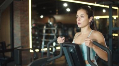 Spor salonunda kol egzersizi yapan seksi fit kız. Spor kulübünde kıvırcık saçlı kız